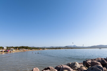 Panorama of the beach in Jalisco, Mexico in which you can see the curvature of the beach along with the boardwalk and people enjoying their vacations