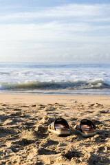 Panorama of beach in Jalisco, Mexico with breaking waves arriving very slowly and in the sand you can see footprints of a person walking on the sand and some sandals abandoned in the sand