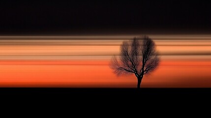 Solitary tree silhouette against a vibrant sunset with motion blur effect.