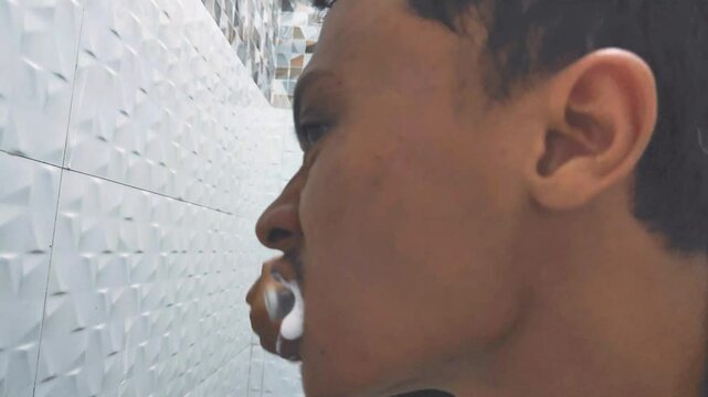 A man is brushing his teeth. Brush your teeth to maintain health.