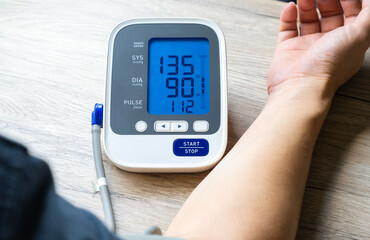Man check blood pressure monitor and heart rate monitor with digital pressure gauge. Health care and Medical concept	