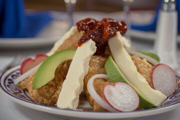 Mexican deep fried pork skin Chicharron with fresh cheese avocado slices and smoked chipole peppers.