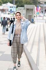 Obraz premium young beautiful woman posing in blue denim jacket outside