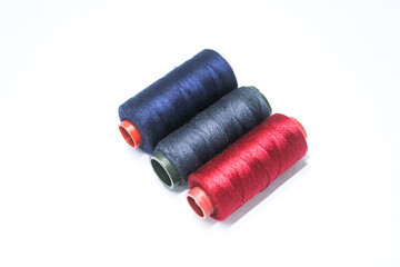 Photo of three skeins of blue, black and red thread. Usually used for sewing clothes. Isolated white background.