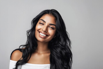 Naklejka premium beautiful indian woman with long hair smiling for skincare ad or hair products 