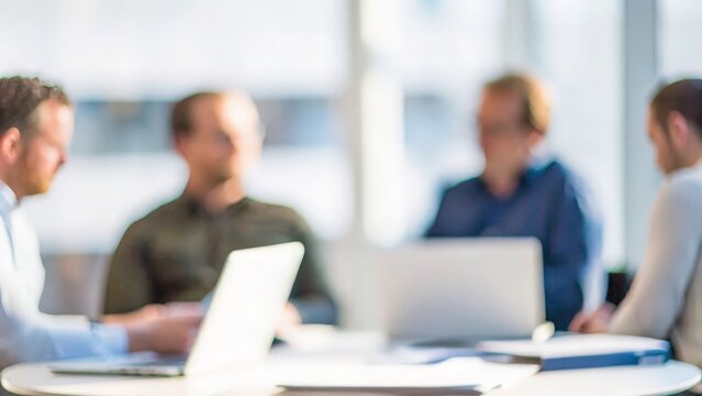 A softly blurred background of a small group in a breakout session during a conference.
