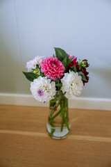 Dahlia bouquet with red, white, and pink blooms on blue background