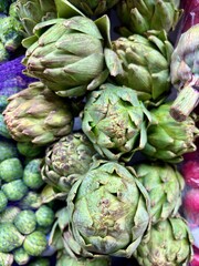 Fototapeta premium Closeup of fresh green artichokes piled in a market display