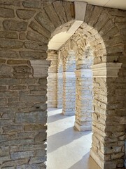 Sunlit stone arches with pathway with textured surfaces and shadows