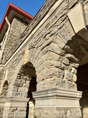 Obraz premium Closeup detail of stone arches and a red roof on a historic building