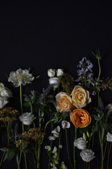 Vibrant flowers including roses and wildflowers on black backdrop