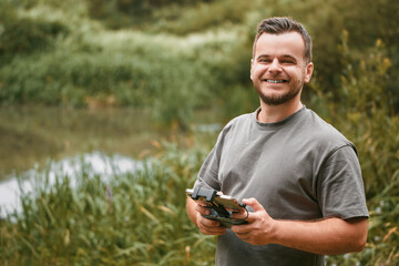 Man holding UAV remote control outdoors.