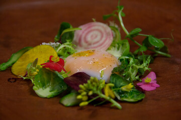 Exquisite winter salad crowned with a delicate quail egg yolk, Sichuan pepper, and vibrant herbs.