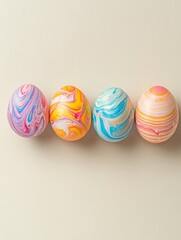 Fototapeta premium Marbled easter eggs in vibrant colors arranged in a row against a light neutral background for festive decoration concepts