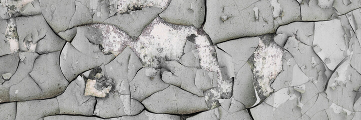 Peeling paint on the wall. Panorama of a concrete wall with old cracked flaking paint. Weathered...