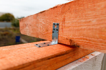 A wooden beam with a metal bracket attached to it