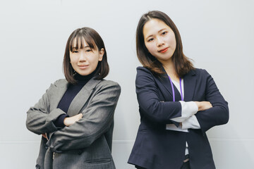 two businesswomen arm in arm
腕を組む2人のビジネスウーマン