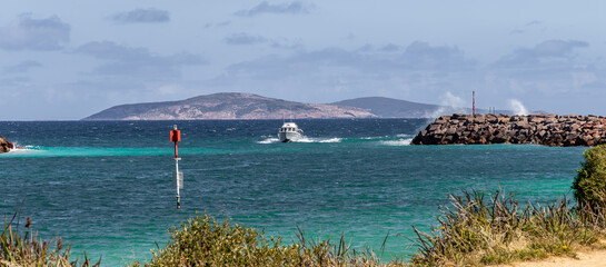 A boat entering Bandy Creek fishing boat harbor, Esperance Western Australia.