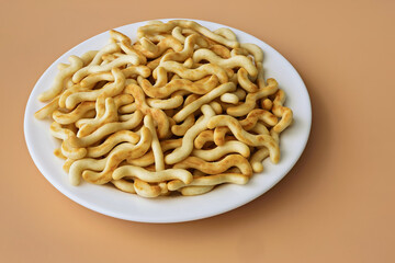 Crunchy organic mini crackers on a plate on an orange background