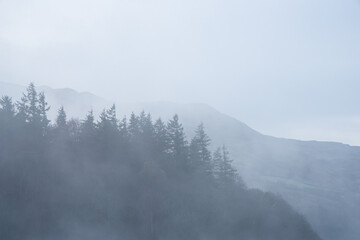 Absolutely stunning dramatic atmospheric landscape image of Derwentwater during foggy sunrise in Autumn