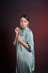Woman with beautiful figure posing for photo in dark studio. Concept of elegance and beauty.