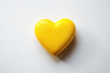 Fototapeta premium A joyful yellow heart against a pristine white background: perfect love imagery.