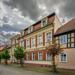 Fototapeta premium Denkmalgeschütztes historisches Postamtsgebäude am Kirchplatz in Neustadt (Dosse) - Inschrift: Postamt