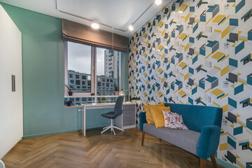 Modern interior design of the children's room. A table by the window with a Roman curtain, .a white wardrobe and a sofa against the wall with a multicolored print.