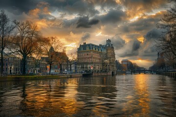 Fototapeta premium Scenic view of amsterdam canal at sunset with dramatic sky and traditional dutch houses