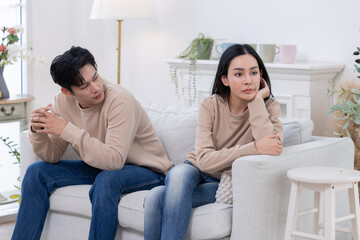 Relationship struggle between a couple sitting on a couch in a cozy living room during a tense...