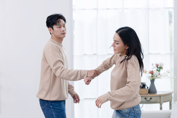 Angry man grabbing his scared partner hand while they have a fight