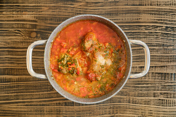 Delicious homemade turkey stew simmering in a pot on a rustic wooden table