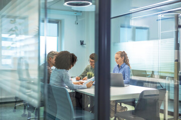 Business office with people casual wear, with blurred bokeh background, view from glass wall