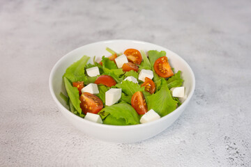 Vegetable salad with fresh tomato and feta cheese. Healthy food. Top view.