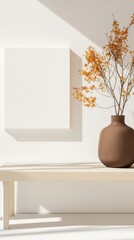 A minimalist setup with a brown vase holding autumn branches on a wooden table. Soft shadows create a calm and serene atmosphere.
