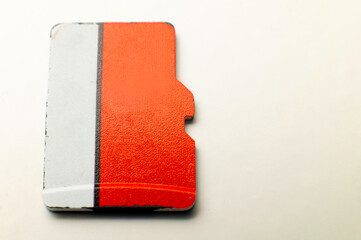 Top view of unrecognizable red and white micro sd flash drive on white background. Used flash drive...