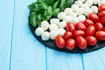 Basil leaves , cherry tomatoes and mozzarella cheese . In form italian flag food photography