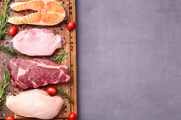 Mix of raw meat and fish . Salmon , beef , pork , chicken staek . Top view