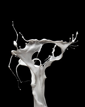 Energetic splash of milk or white paint isolated on black background