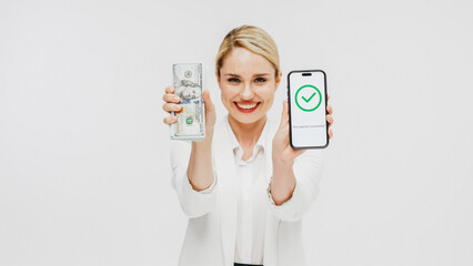 A business young woman on a white background holds money and a phone in her hands with confirmation...