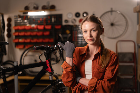 Small business of mechanic or engineer. Small business owner woman making service maintenance for bike, inspection transport working in garage or vehicle workshop - Powered by Adobe