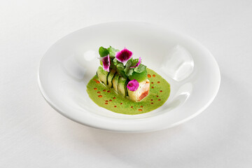 A gourmet dish featuring a delicate piece of fish, surrounded by a vibrant arrangement of fresh vegetables and edible flowers.