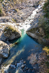 Mountain river flows in turbulent foaming stream in stone bed between huge boulders. Pure emerald water originates from mountain glaciers of North Caucasus. Dombay. Karachay-Cherkessia.