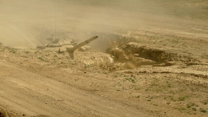 heavy tank crosses a ditch with mud and water