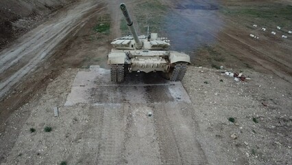 drone view - heavy tank climbs over walls
