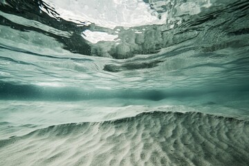 Fototapeta premium Underwater scene: rippled sand, clear water, light above.