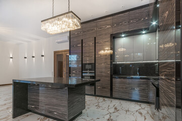 Elegance and luxury of the kitchen interior. White floor tiles. Stylish design of the .kitchen set with built-in modern appliances.