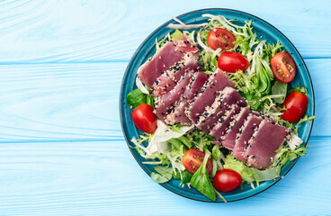 Salad with raw tuna , sesame and cherry tomatoes photography . Top view