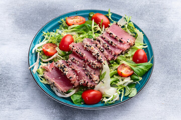 Salad with raw tuna , sesame and cherry tomatoes photography . Top view
