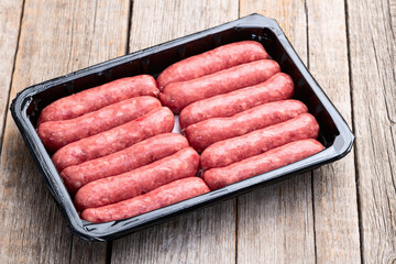 Raw beef sausages with rosemary and tomatoes photography . Top view